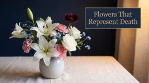 Soft, dignified arrangement of white lilies, white roses, and forget-me-nots representing traditional flowers that symbolize death and mourning